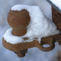 a rusty, snow-covered trailer hitch