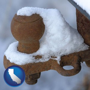 a rusty, snow-covered trailer hitch - with California icon