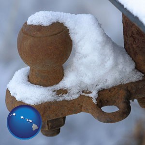 a rusty, snow-covered trailer hitch - with Hawaii icon