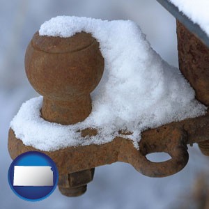 a rusty, snow-covered trailer hitch - with Kansas icon