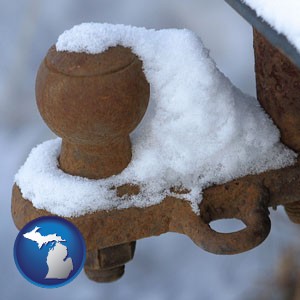 a rusty, snow-covered trailer hitch - with Michigan icon