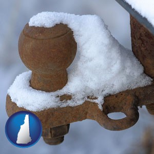 a rusty, snow-covered trailer hitch - with New Hampshire icon