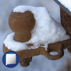 a rusty, snow-covered trailer hitch - with New Mexico icon