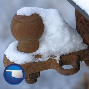 a rusty, snow-covered trailer hitch - with Oklahoma icon