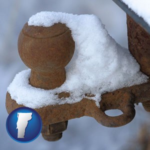 a rusty, snow-covered trailer hitch - with Vermont icon